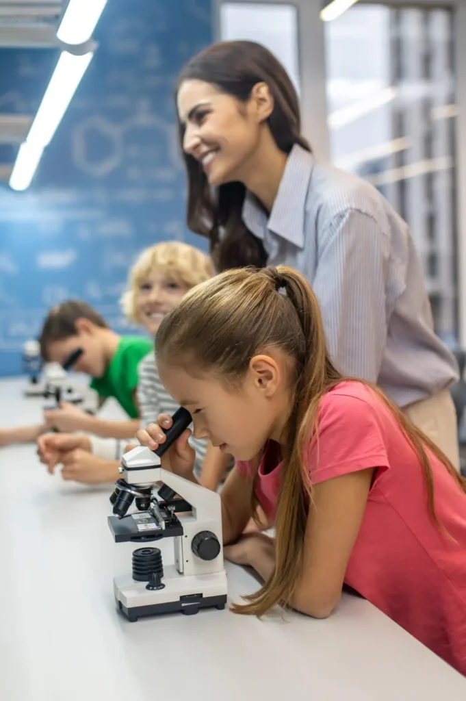 Biology tutor using digital microscope to show cellular structures to student in Dubai